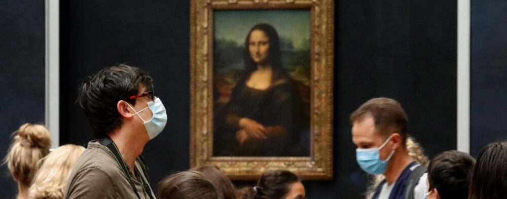 Visitantes con mascarillas, frente a la 'Mona Lisa', de Leonardo da Vinci, en el museo del Louvre en París, en la reapertura al público después de casi 4 meses de cierre debido a la pandemia del coronavirus.