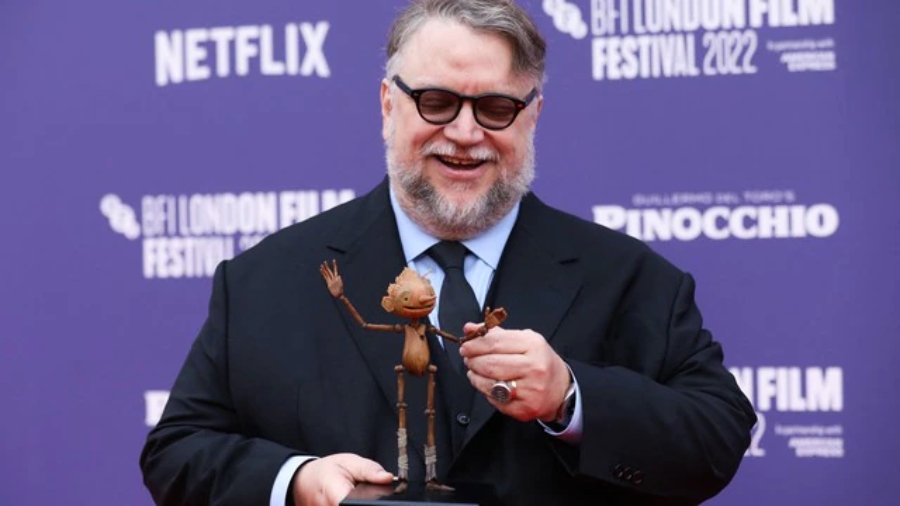 Guillermo del Toro sosteniendo un muñeco de madera