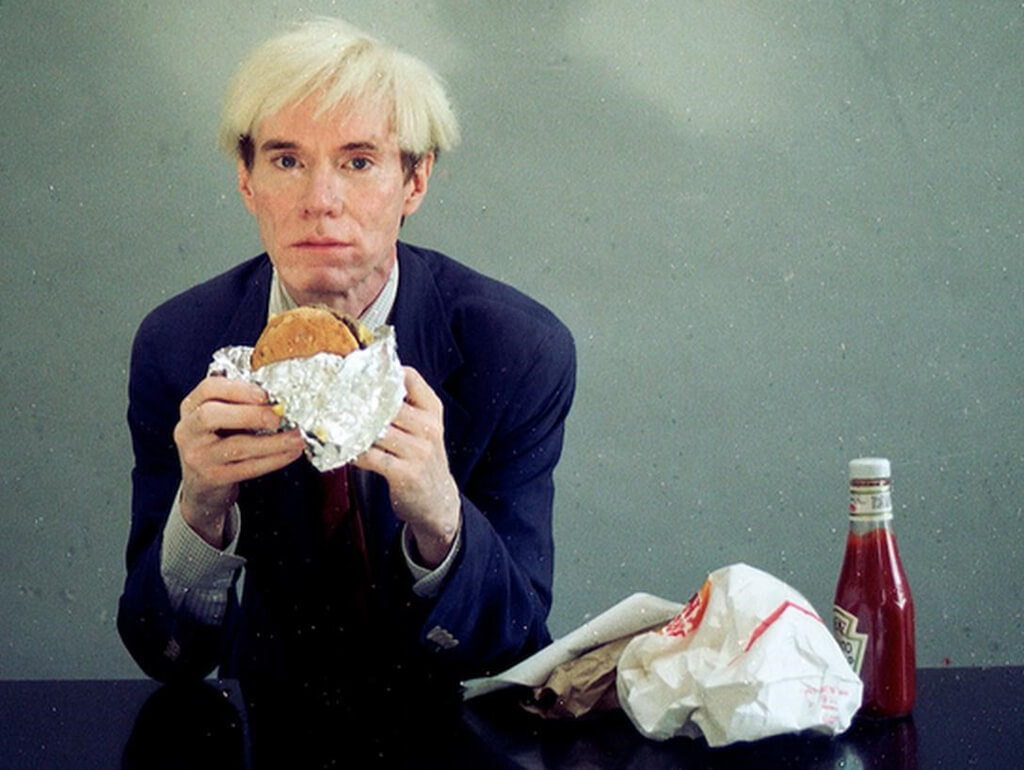 Foto de Andy Warhol comiendo una hamburguesa 