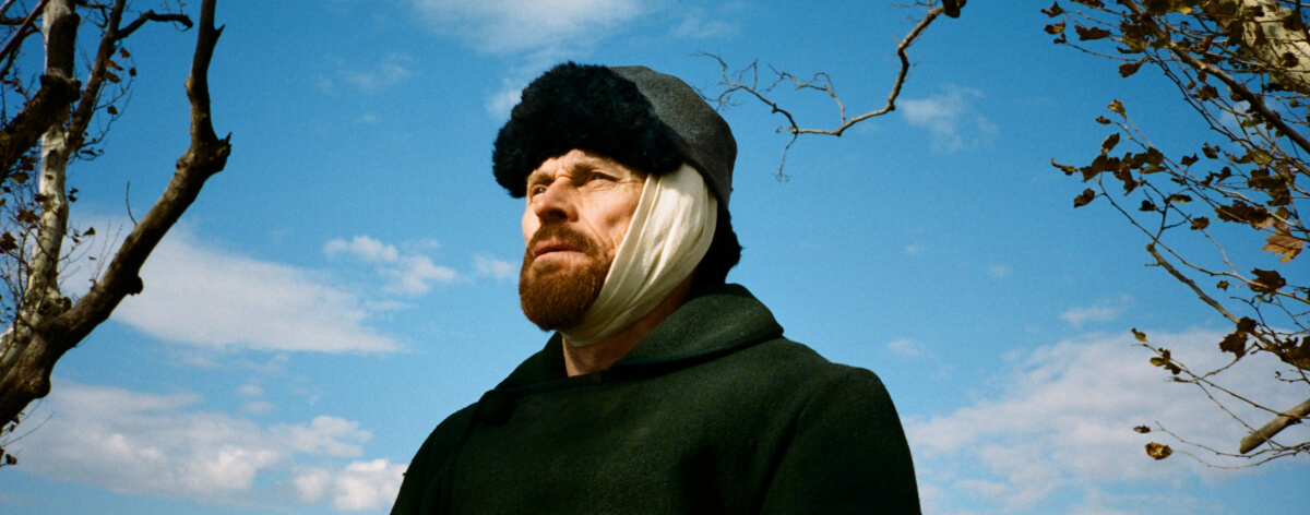 Imagen de Willem Dafoe como Van Gogh bajo el cielo azul en la película At Eternitys Gate