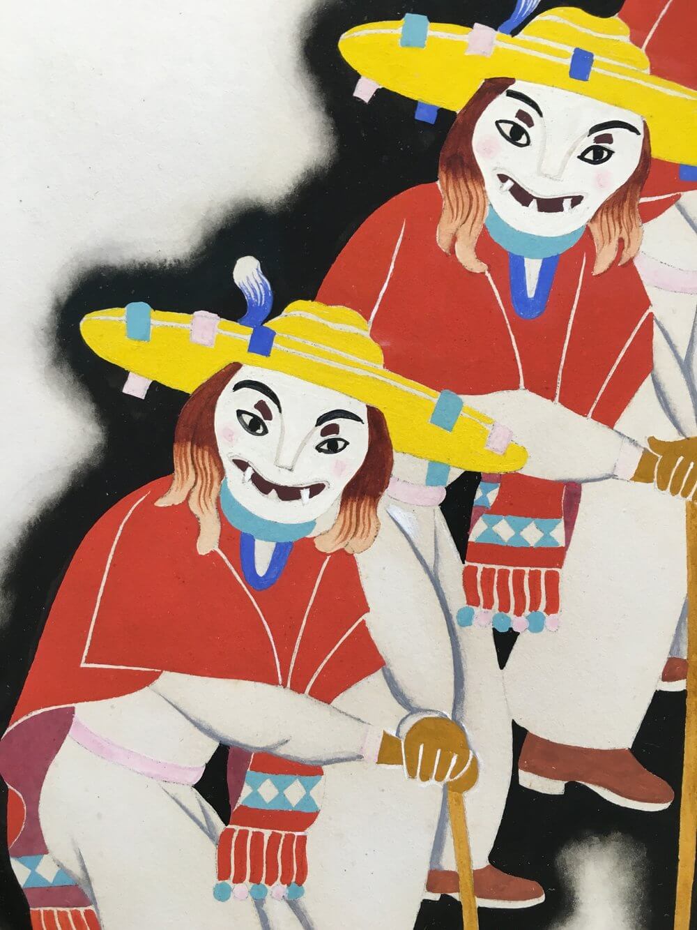 Obra de dos personas con máscara y trajes típicos 