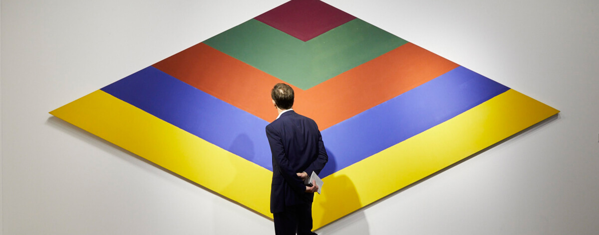 foto de un hombre viendo una obra colorida y geométrica - México presente en el Art Basel