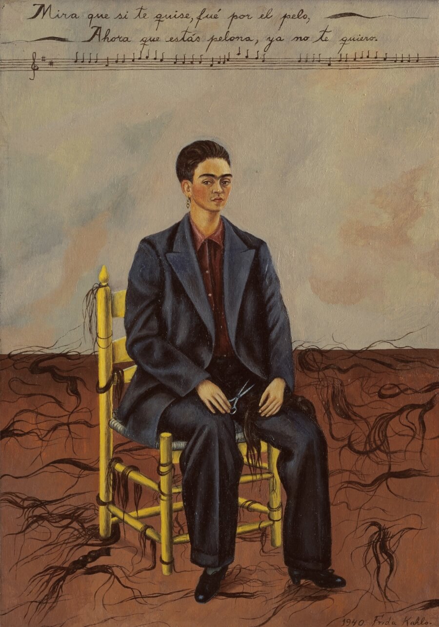 Pintura de Frida Kahlo vestida de hombre, sosteniendo unas tijeras con su mano derecha y el cabello alrededor de ella recortado