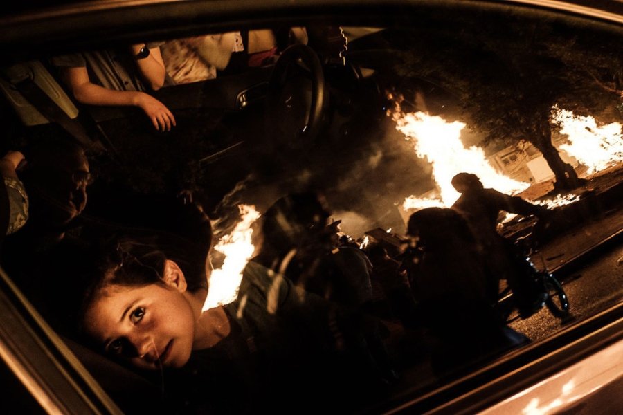 The best street photographs / girl looking through the windshield at the bonfires