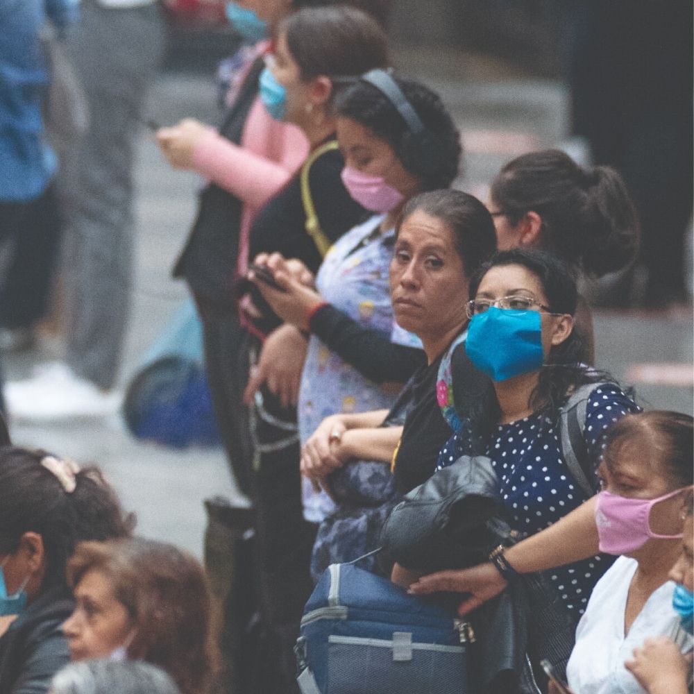 mujeres con cubrebocas mirando su celular, esperando el metro en Pantitlán, Ciudad de México
