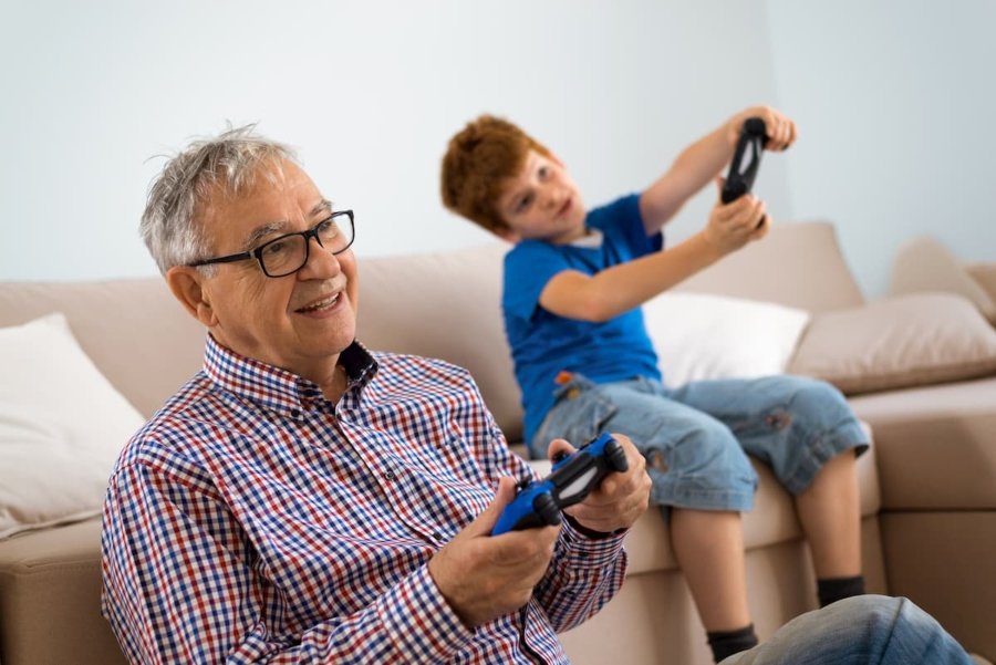 Abuelo jugando videojuegos con niño
