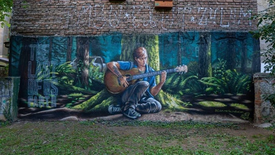 Mural de Metod que muestra a Ellie de The Last of Us part II tocando la guitarra debajo de un árbol en medio del bosque