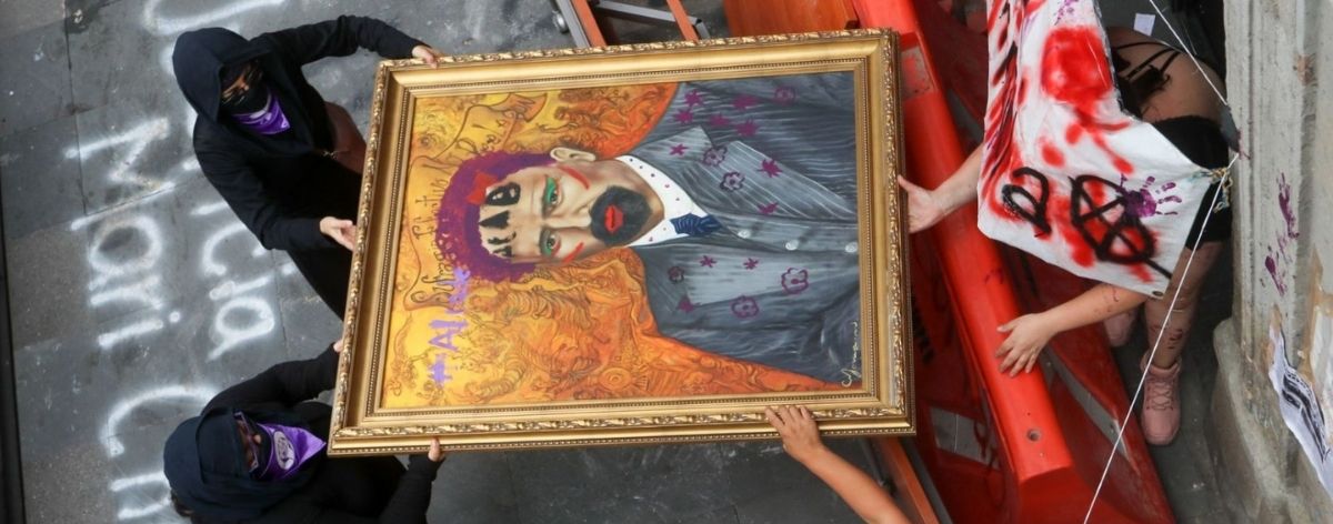 manifestantes sosteniendo el cuadro vandalizado de Francisco I. Madero