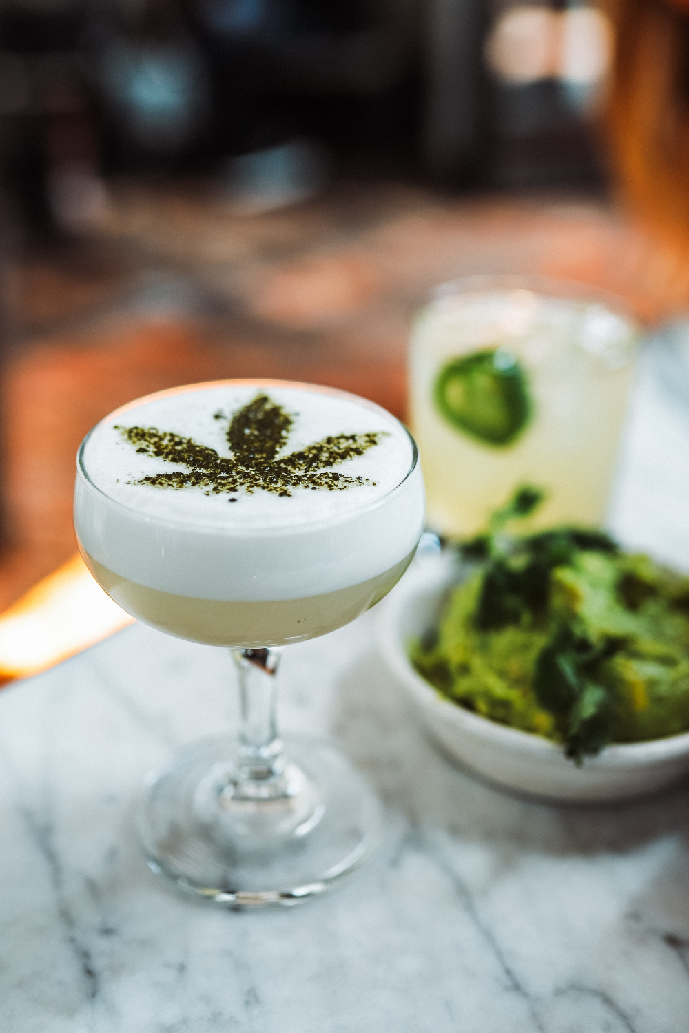 copa de cristal con bebida a base de cannabis con thc y decoracion de planta de marihuana