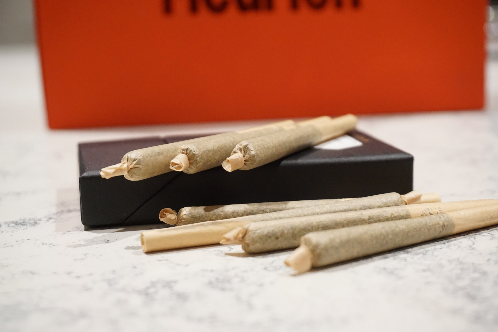 cigarros o porros de marihuana envueltos en papel café spbre una mesa de mármol 
