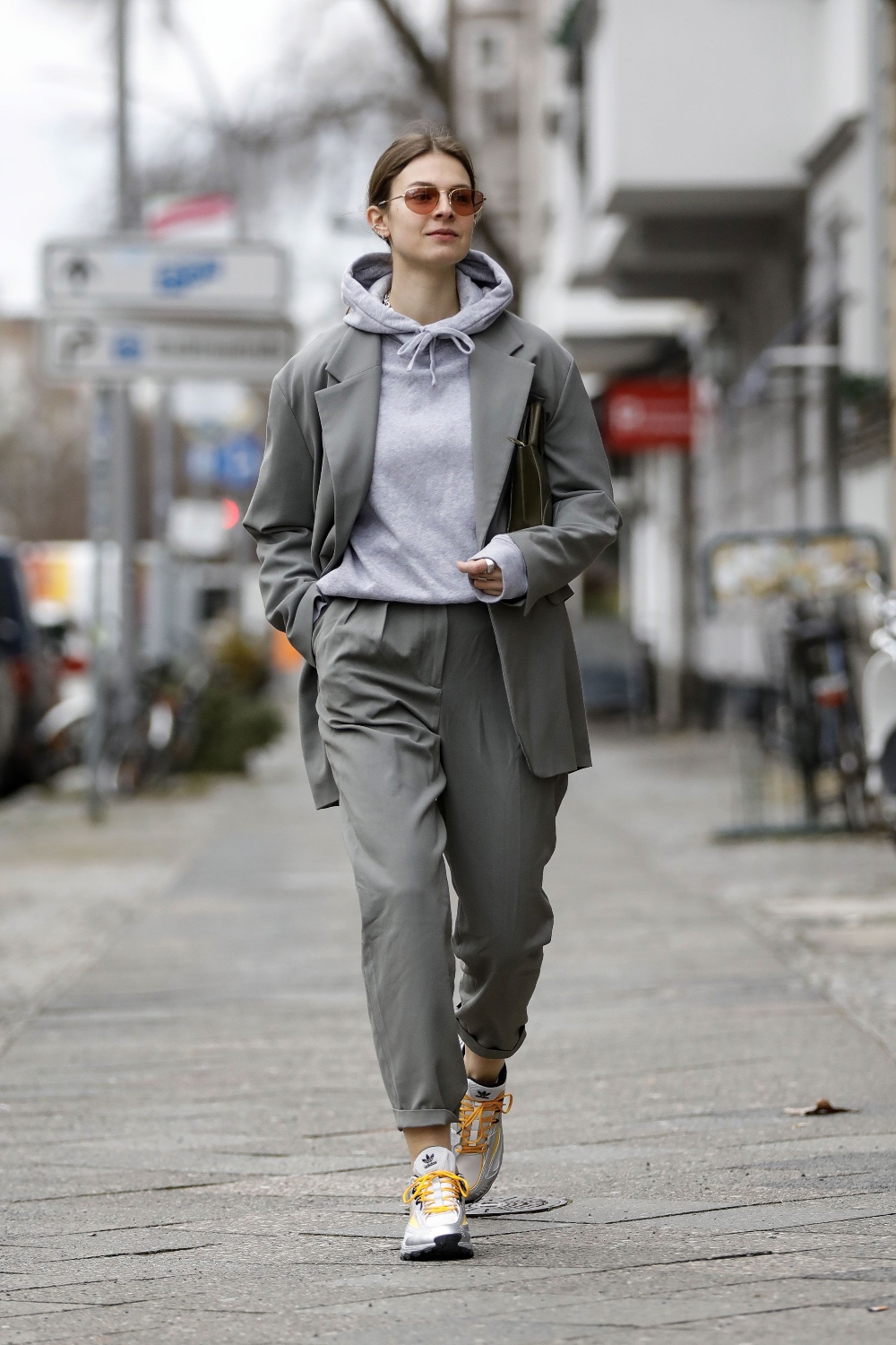 mujer en la calle con saco y pantalon grises